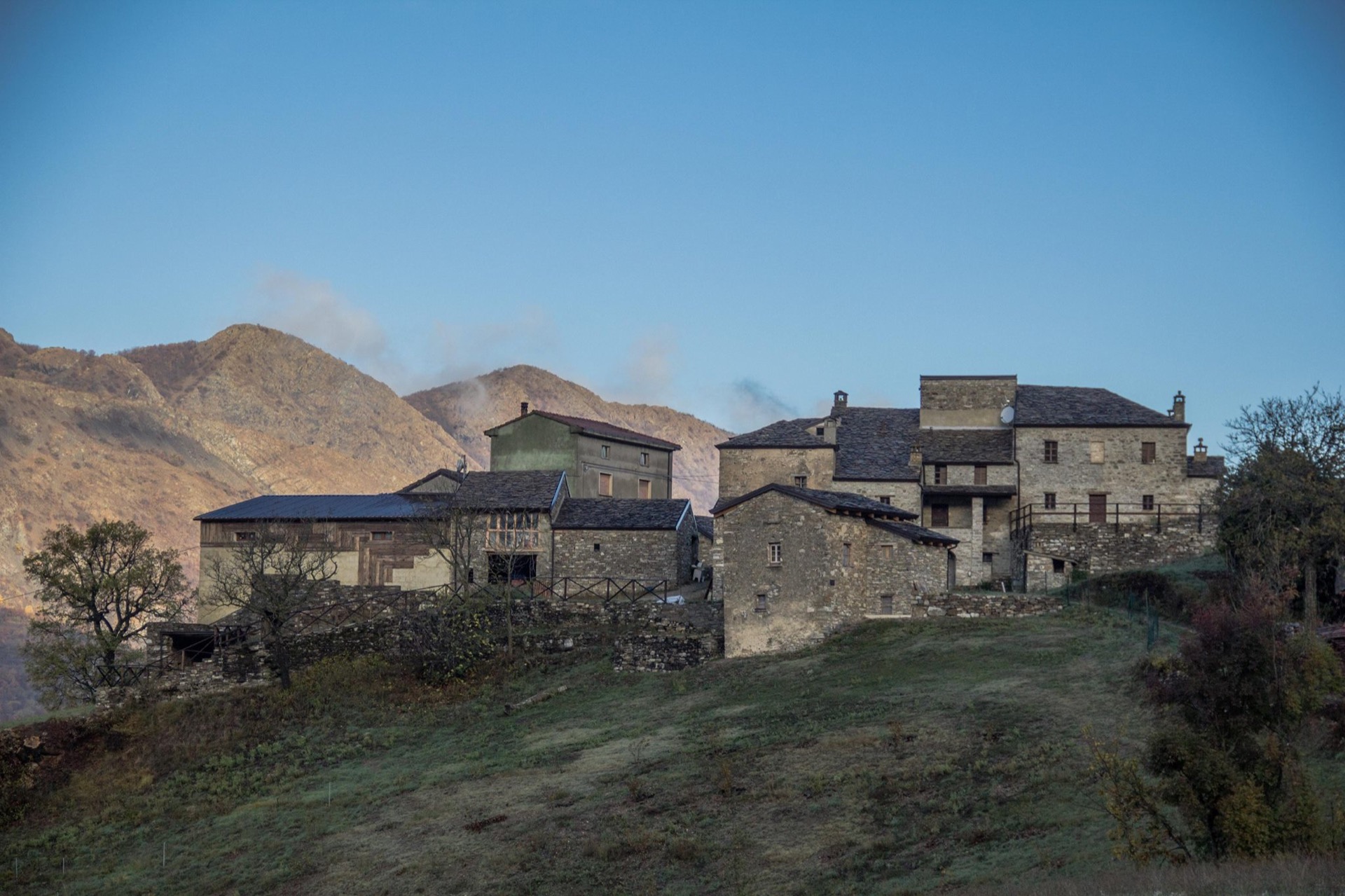 Il borgo di pietra dell'Ecovillaggio Tempo di Vivere all'alba, con i monti sullo sfondo